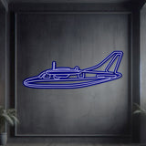 Neon‑lit Mitsubishi MU‑2K silhouette wall art, textured matte steel with floating neon frame for dynamic 3D depth